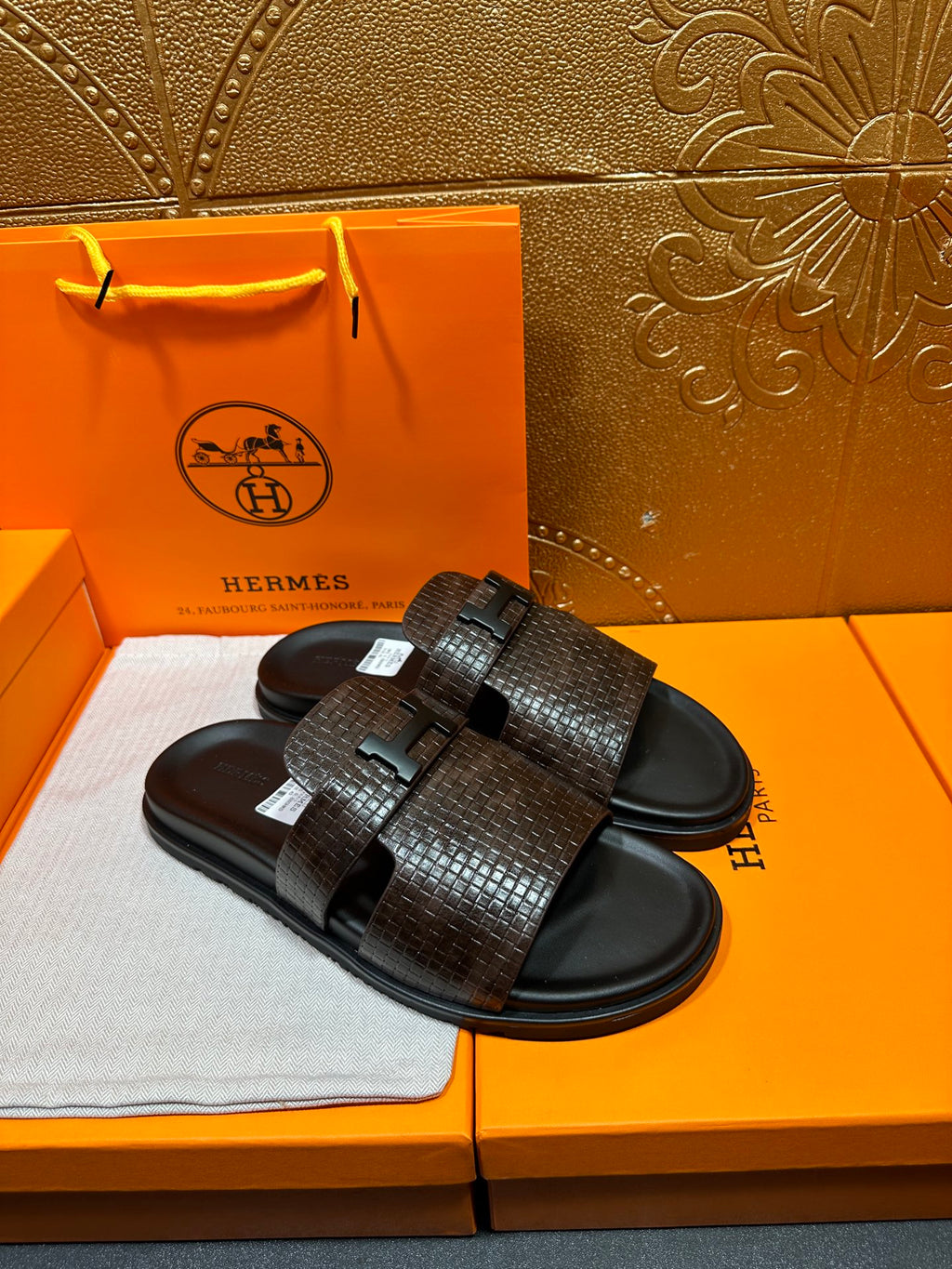 Hermes textured slide sandals laid flat, dark brown top strap with black buckle