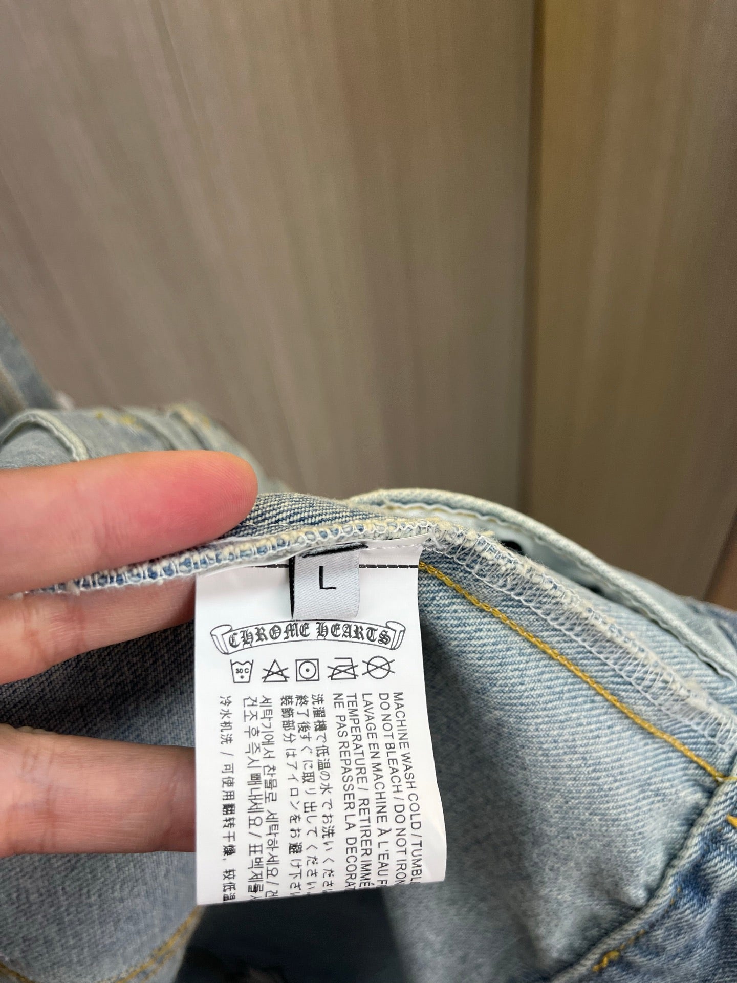 Light blue denim jacket inner neck label, size L, care info