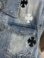 Light blue denim jacket pocket detail with gold button and black flower patches