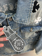 Light blue denim jacket chest close-up with gold button and circular badge