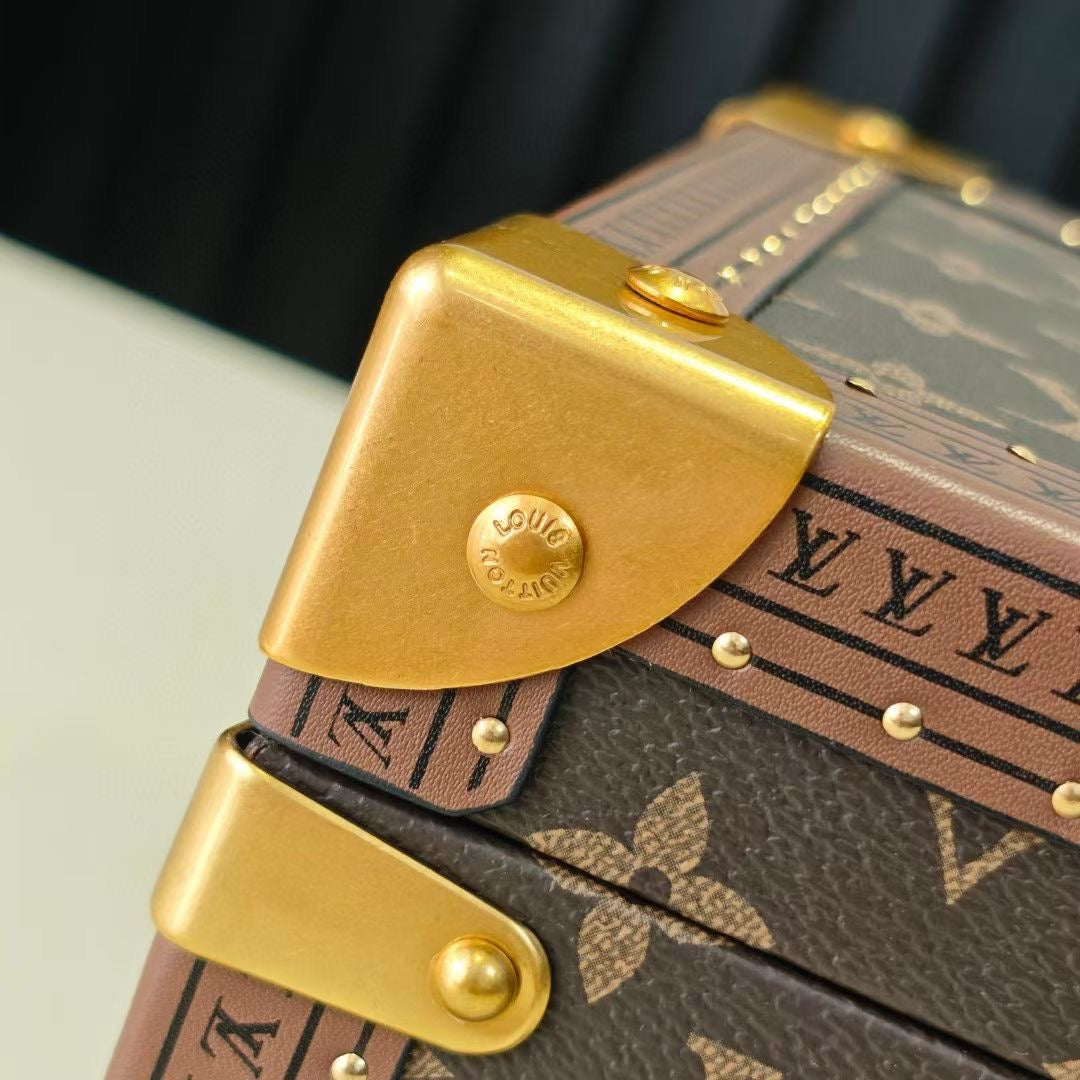 Monogram bag corner strap with gold-tone latch and embossed emblem
