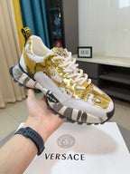 Versace chunky sneakers in gold and white with lace-up front and rubber sole