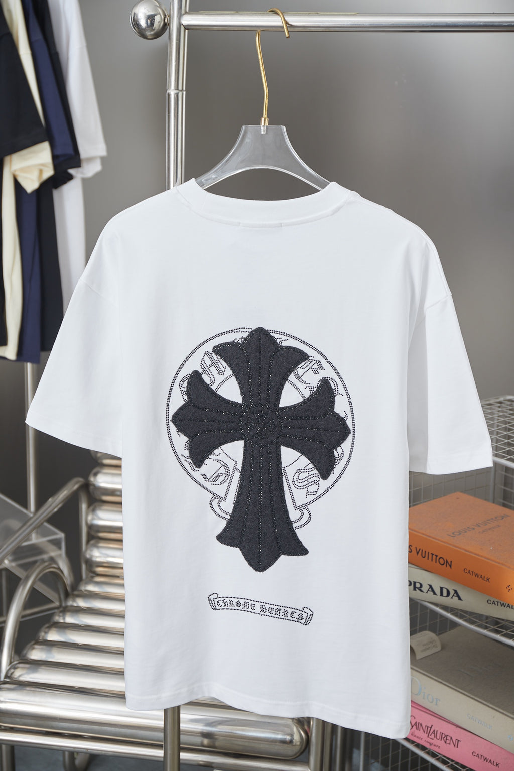 White graphic T-shirt with large black cross emblem centered on the back
