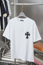 White graphic T-shirt with small black cross emblem on the chest