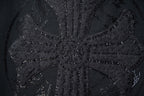 Close-up of black T-shirt rhinestone cross-shaped logo graphic