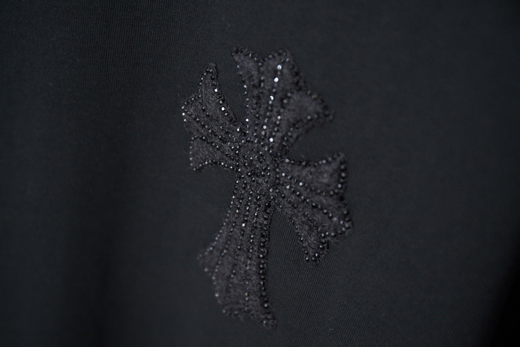 Black T-shirt with textured dark floral cross-style rhinestone graphic