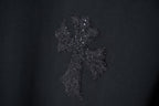 Black T-shirt with textured dark floral cross-style rhinestone graphic