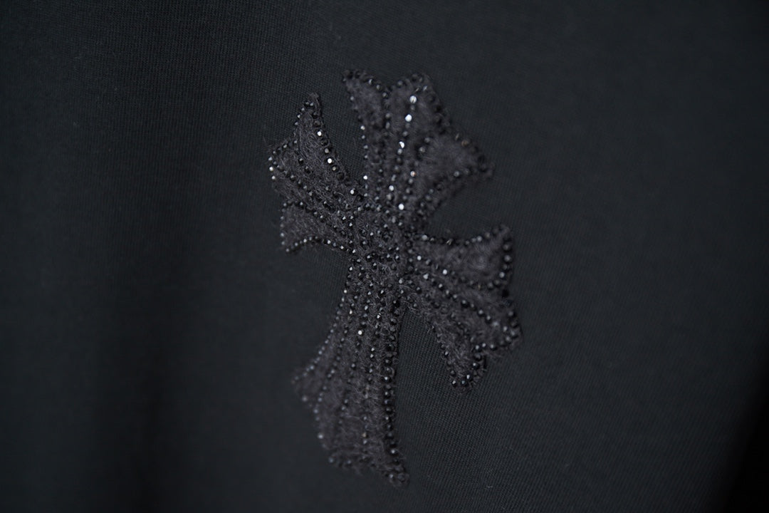 Black T-shirt with textured dark floral cross-style rhinestone graphic