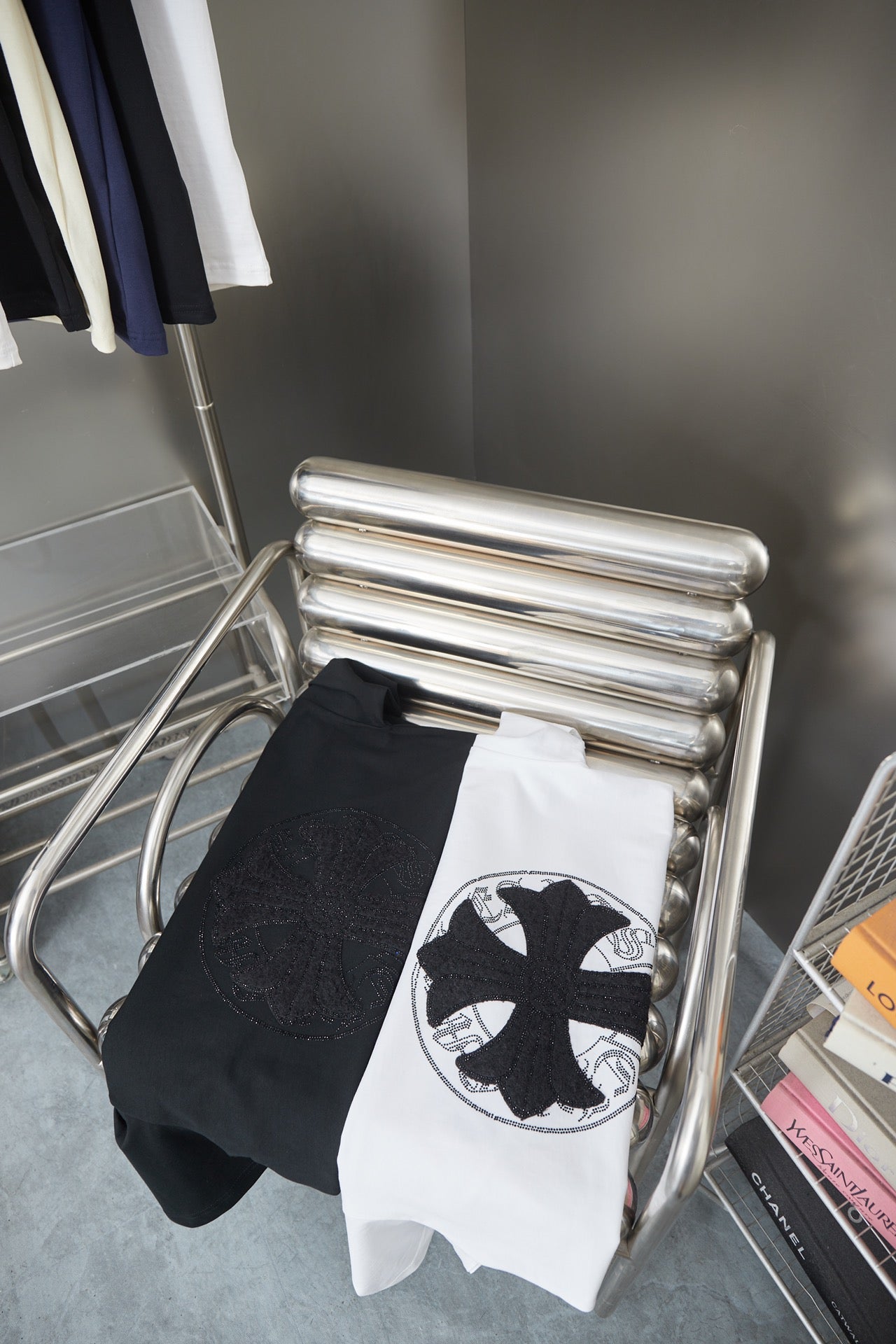 Folded white T-shirt and dark sleeve garment on display rack