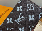 Dark brown textured leather small wallet with white monogram pattern close-up