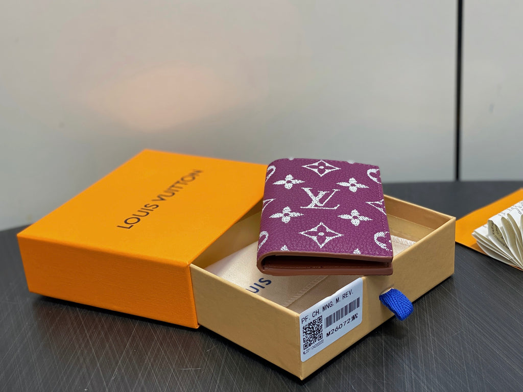 Purple small bag with LV monogram pattern, resting in open gift box