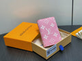 Pink monogram mini wallet in gift box with blue pull tab