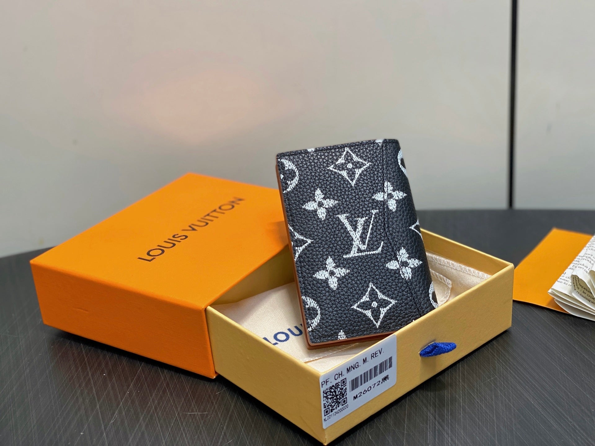 Small wallet in dark navy with white monogram floral pattern, side view