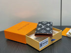 Small wallet with dark navy monogram exterior and beige interior, open