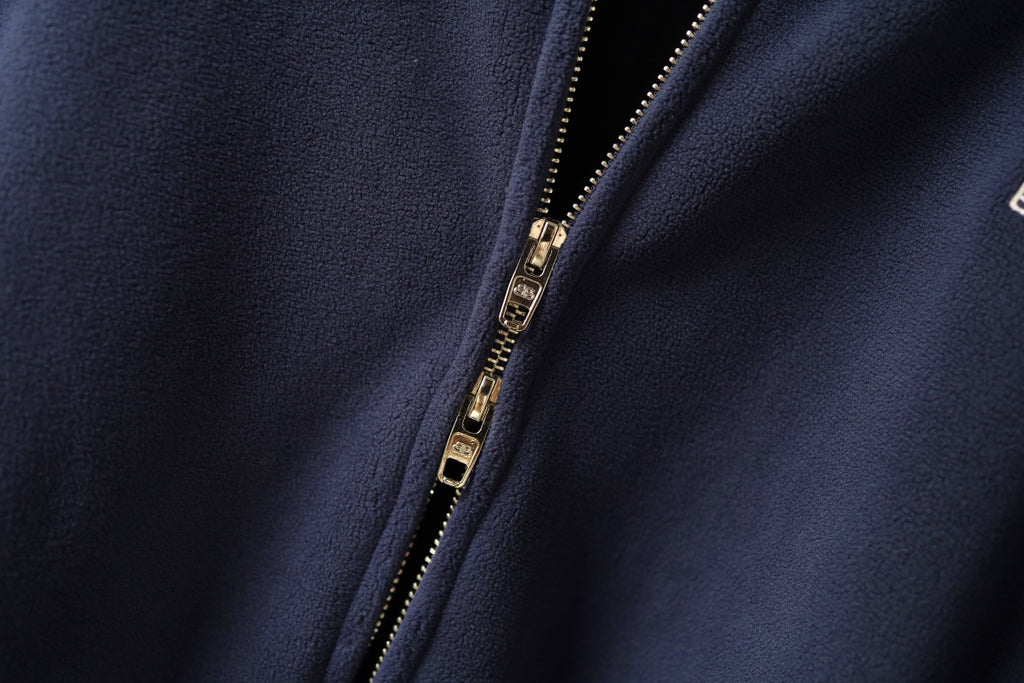 Navy zip-up jacket with gold-tone zipper and smooth front placket