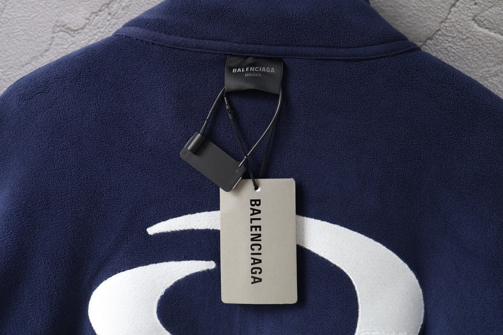 Navy jacket with white Balenciaga graphic and hanging brand tags at collar
