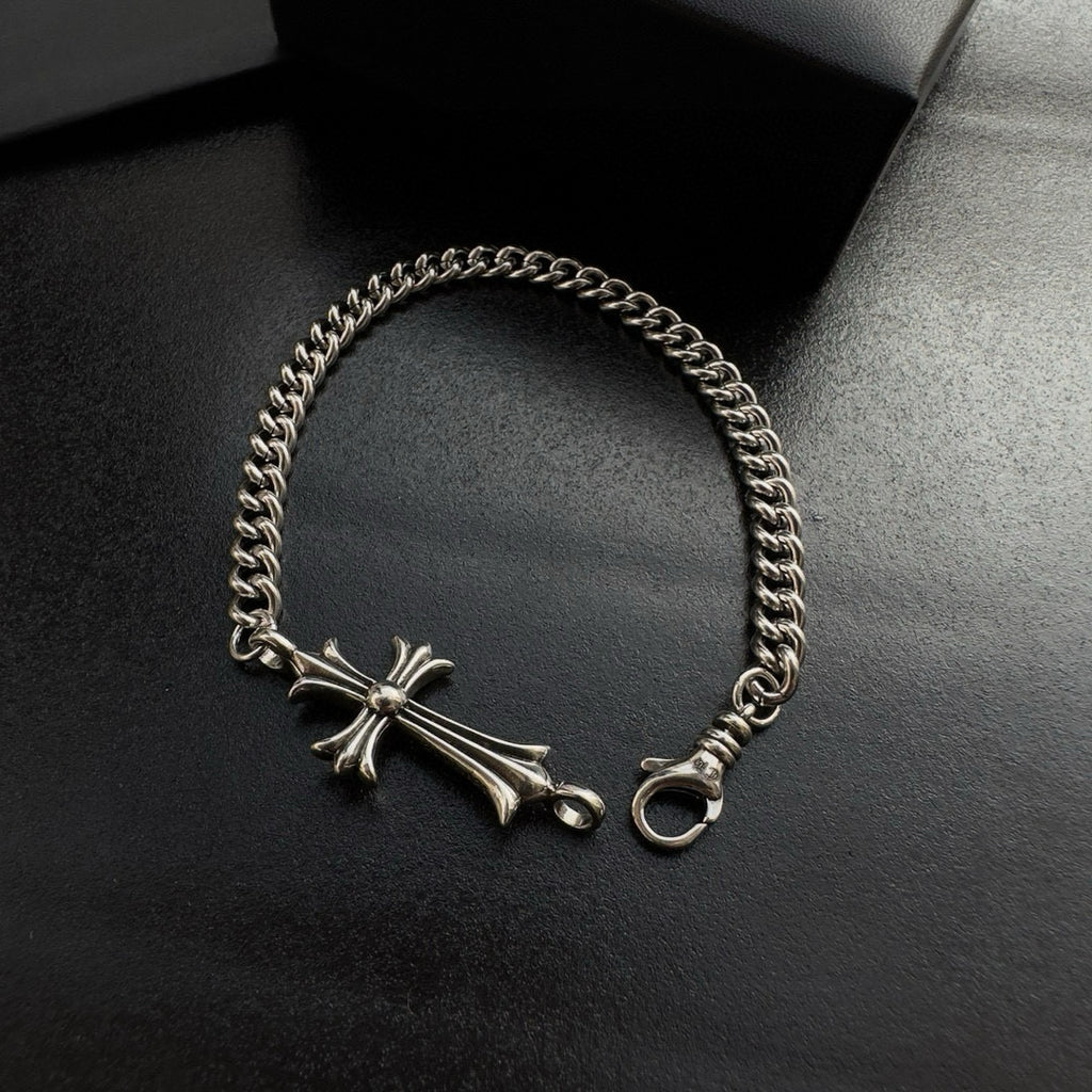 Silver-tone chain bracelet featuring a cross charm and ring clasp