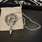 Silver-tone chain necklace with fleur de lis pendant and dagger charm with cloth pouch