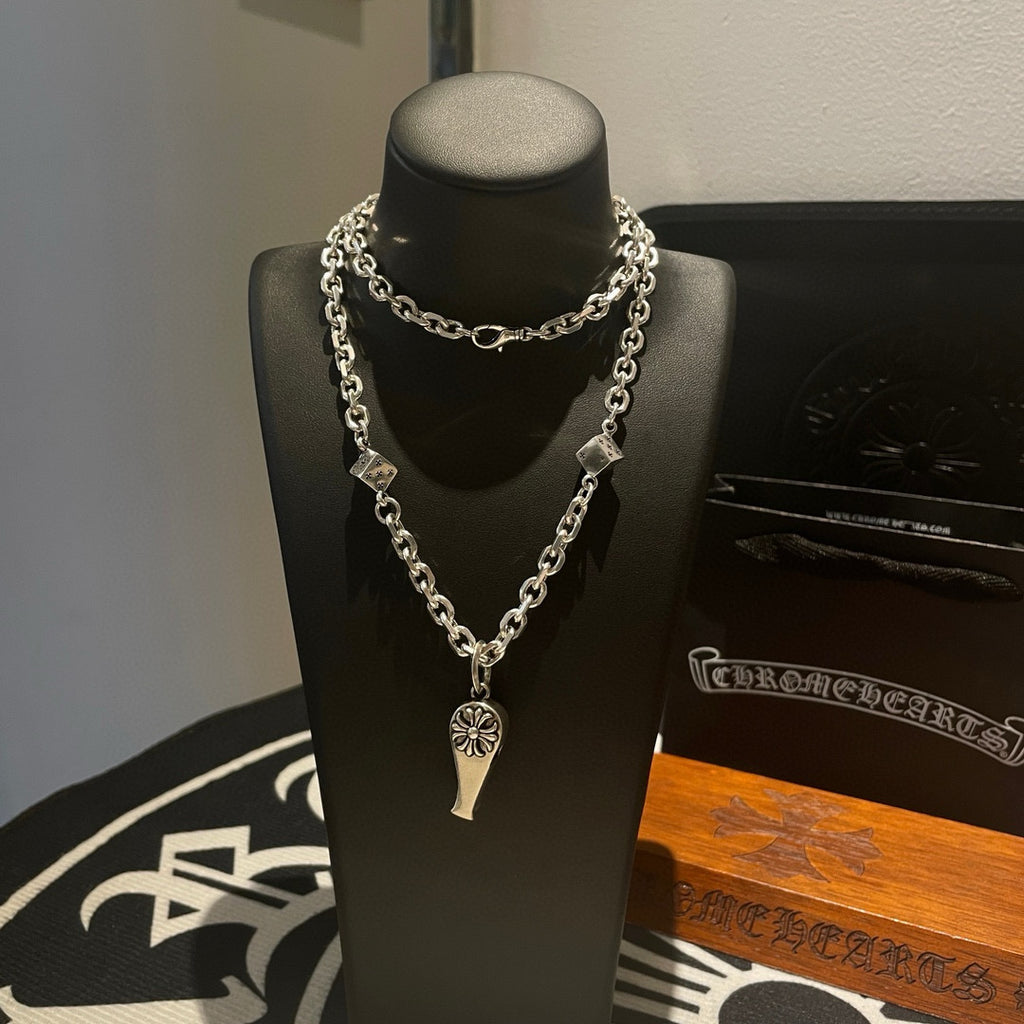 Silver-tone chain necklace with fleur de lis pendant and small square accents