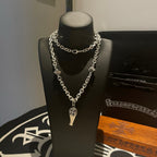 Silver-tone chain necklace with fleur de lis pendant and small square accents