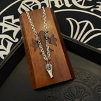 Silver-tone chain necklace with fleur de lis pendant and dagger charm on wooden card