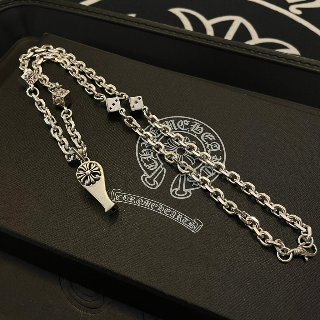 Silver-tone chain necklace with fleur de lis pendant and dagger charm on jewelry box