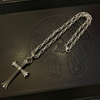 Silver-tone cross pendant necklace with long chain, laid flat