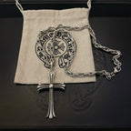 Silver-tone cross pendant necklace on fabric pouch with chain links