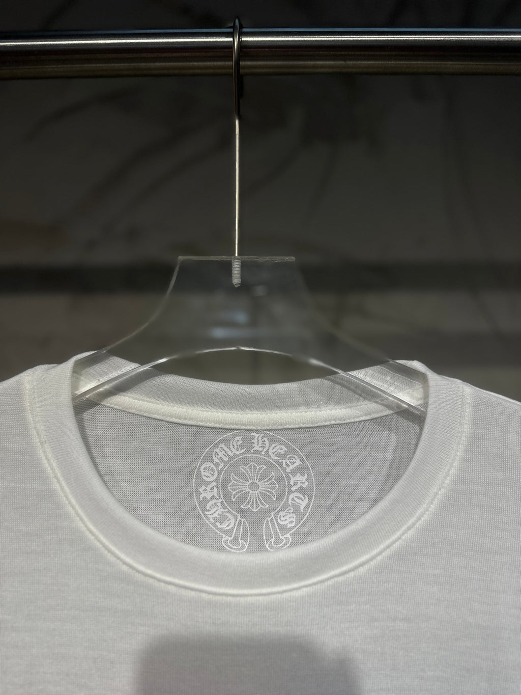 White long-sleeve shirt neckline with circular back logo print.