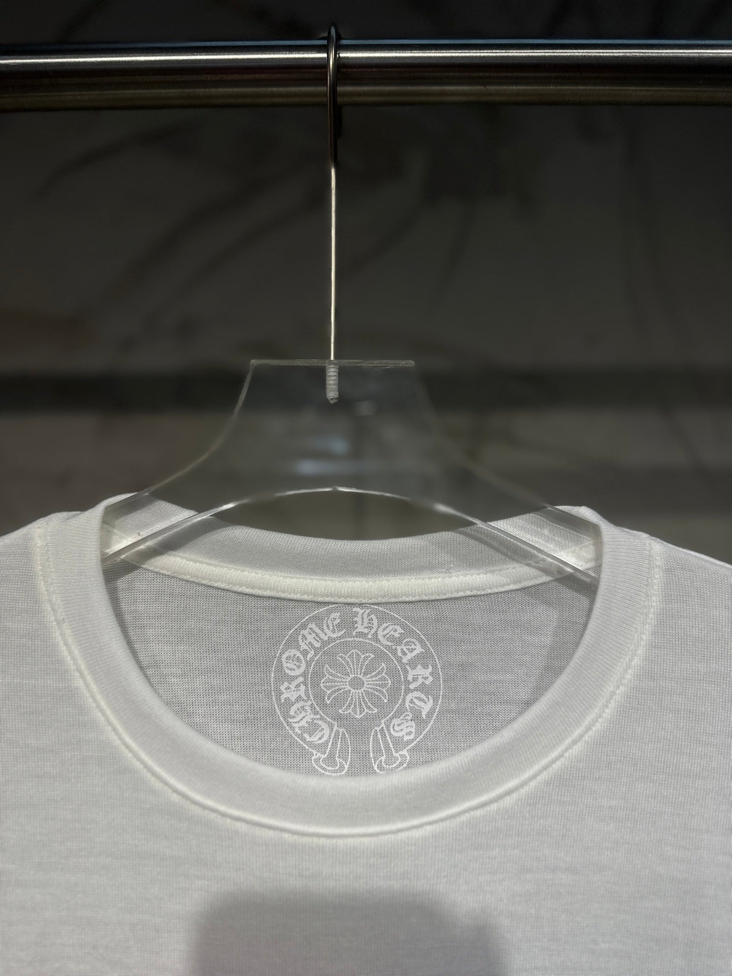 White long-sleeve shirt neckline with circular back logo print.