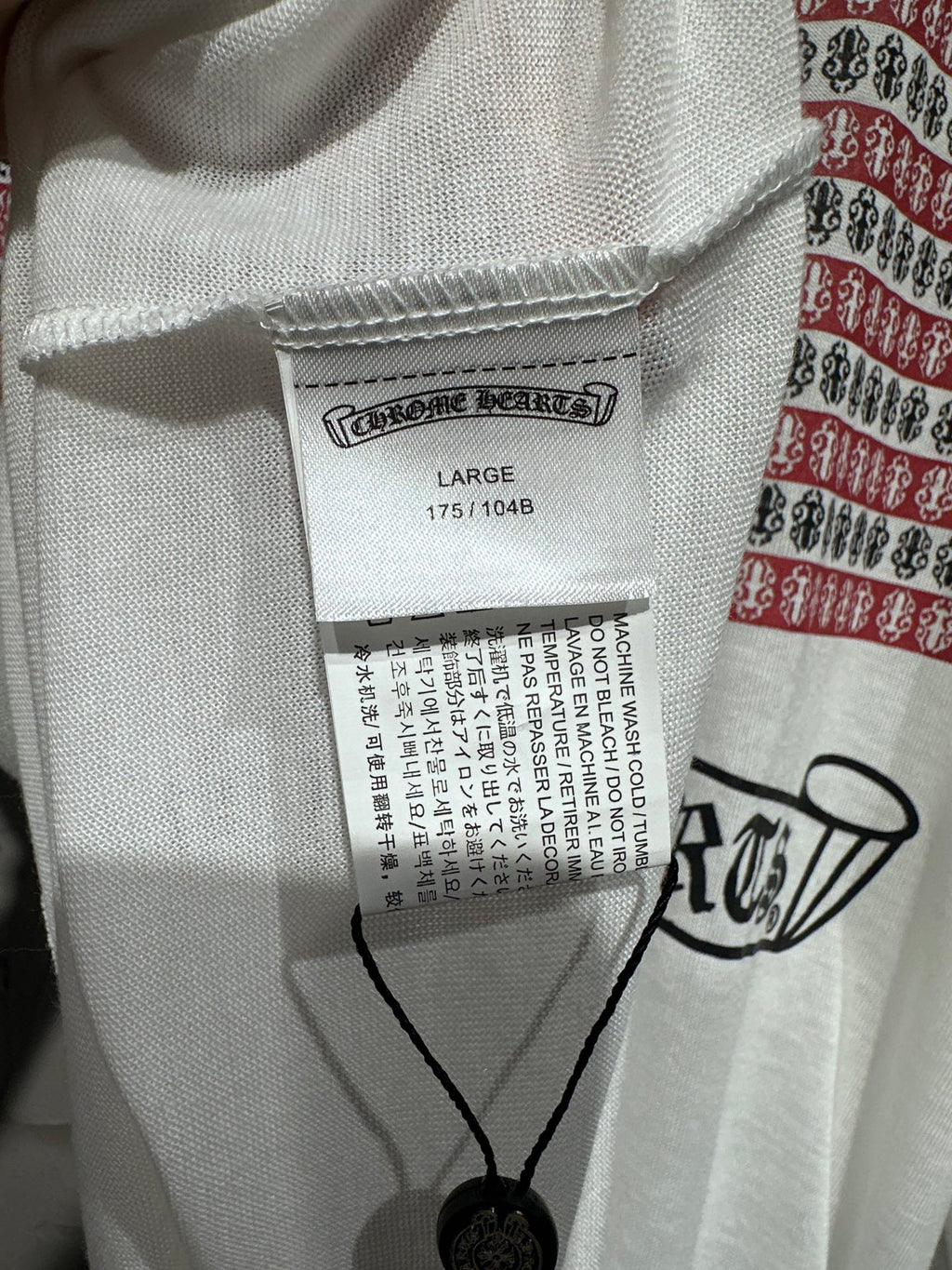 Long-sleeve graphic shirt size label and barcode tag near the collar