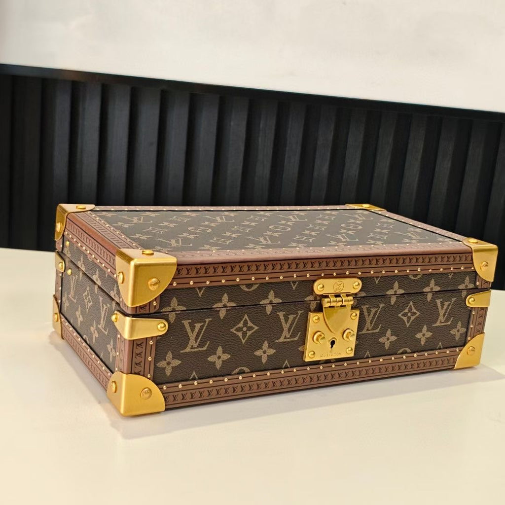 Monogram travel bag with gold-tone corner details, closed top view