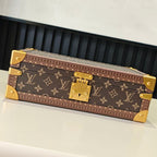Monogram travel bag with gold-tone hardware and hinged clasp, closed