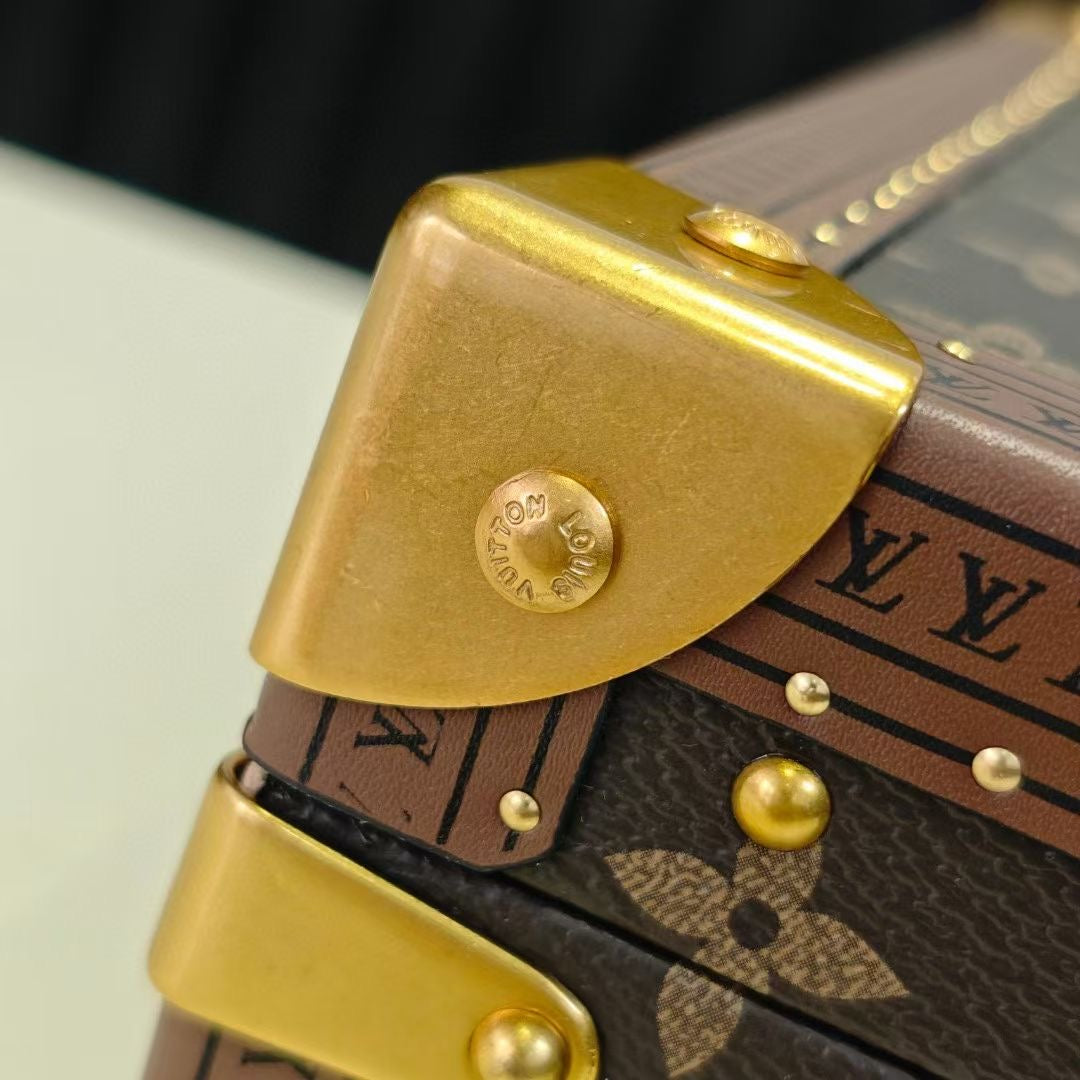 Louis Vuitton monogram bag strap detail with gold corner hardware and studs