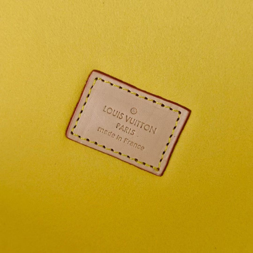 Louis Vuitton Paris leather label on yellow lining, stitched edge close-up