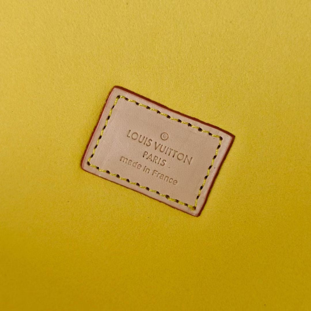 Louis Vuitton Paris leather label on yellow lining, stitched edge close-up