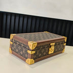 Louis Vuitton monogram trunk bag with gold corner hardware and brown trim, angled view