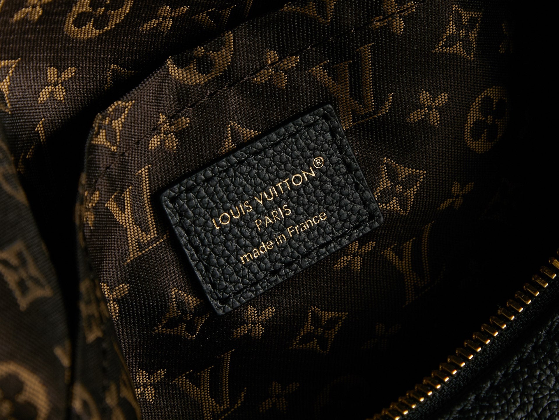 Louis Vuitton made in France label on black lining inside monogram canvas bag.