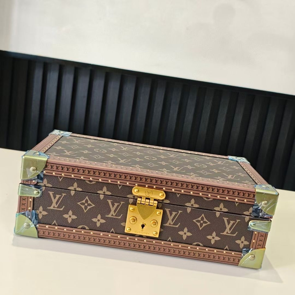 Louis Vuitton monogram trunk with blue-lined interior, closed with gold clasp and hinges