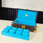 Louis Vuitton monogram trunk open, showing blue organizer insert and gold latch hardware