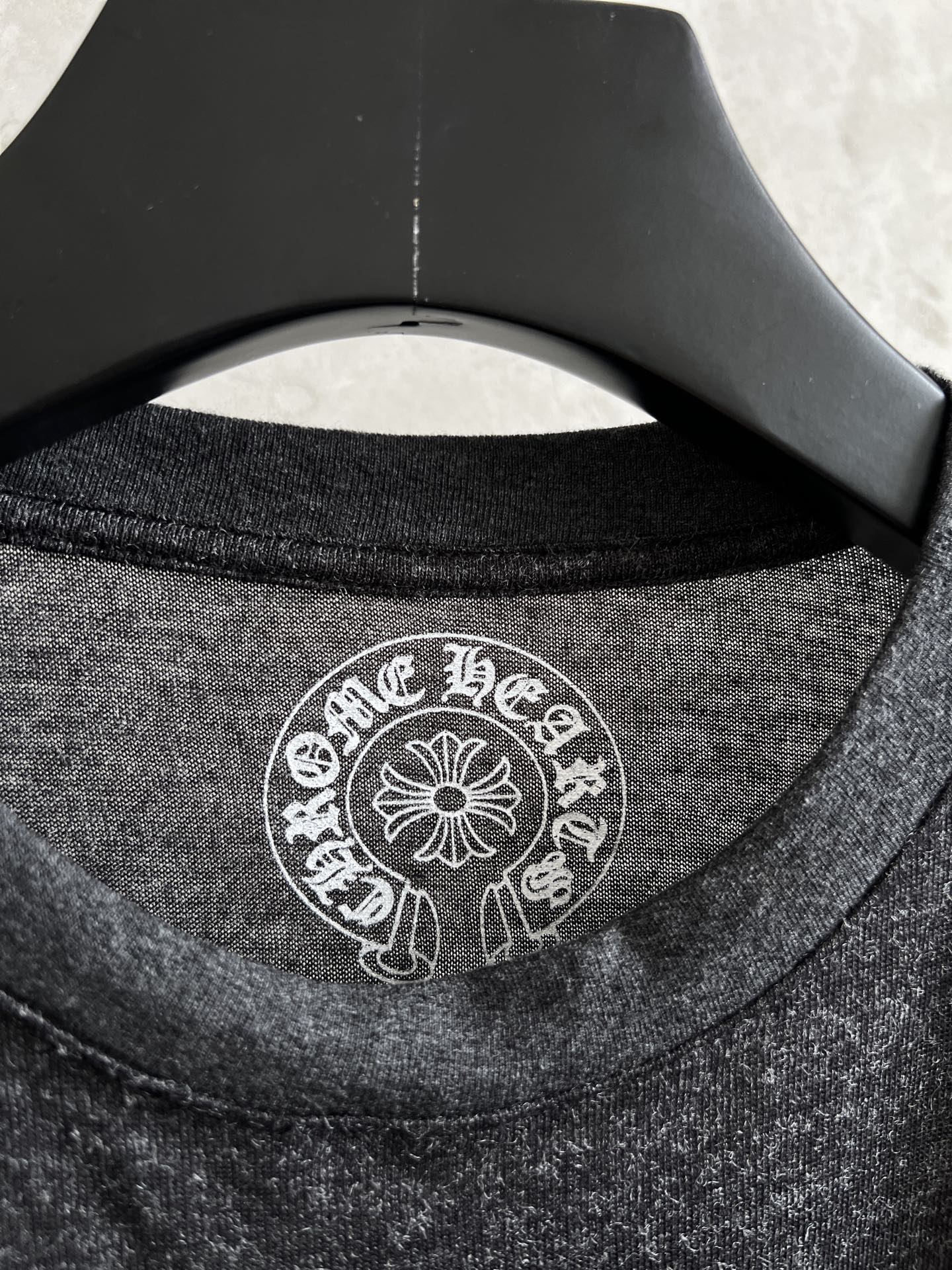 Long-sleeve T-shirt neckline with white circular logo print at the collar
