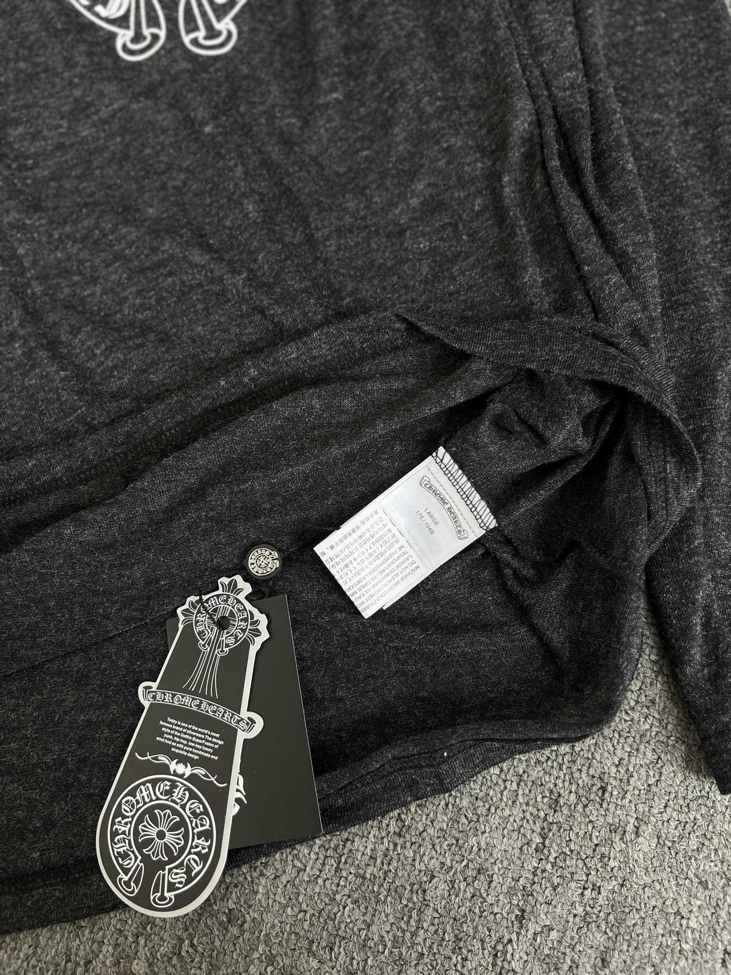 Long-sleeve T-shirt with hang tag labels on dark heather gray fabric fold
