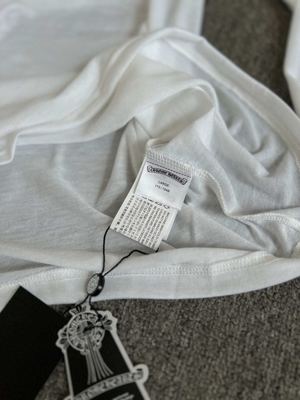 White long-sleeve top with printed hang tag and neckline label