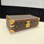 Louis Vuitton monogram trunk bag on tabletop with gold feet and closed lid