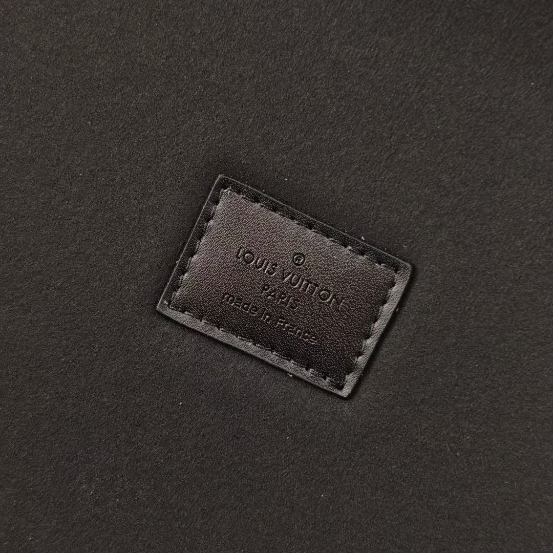 Louis Vuitton monogram trunk leather brand patch on dark fabric