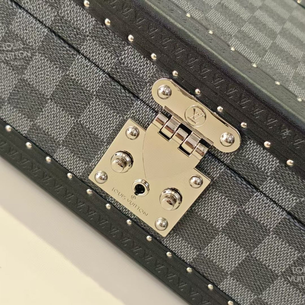 Gold-tone lock plate with logo hardware on gray checkered storage case