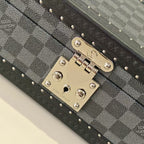 Gold-tone lock plate with logo hardware on gray checkered storage case