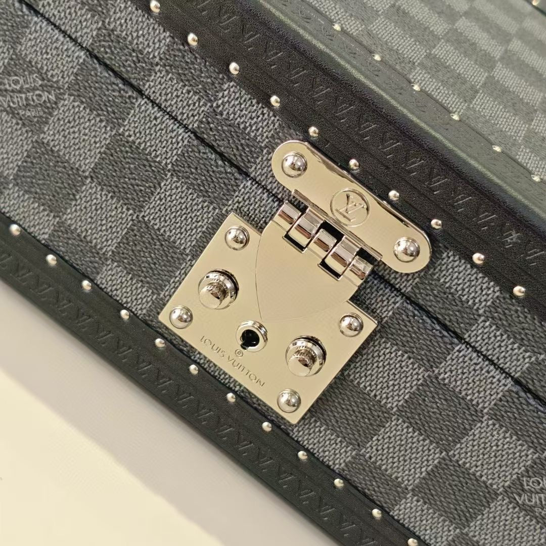 Gold-tone lock plate with logo hardware on gray checkered storage case