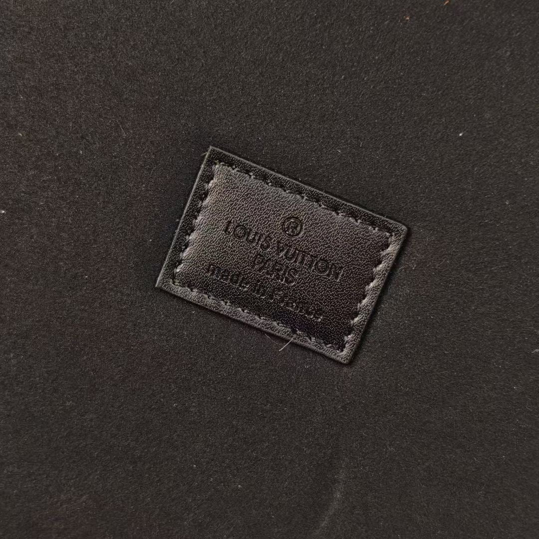 Louis Vuitton branded leather patch on black fabric interior panel