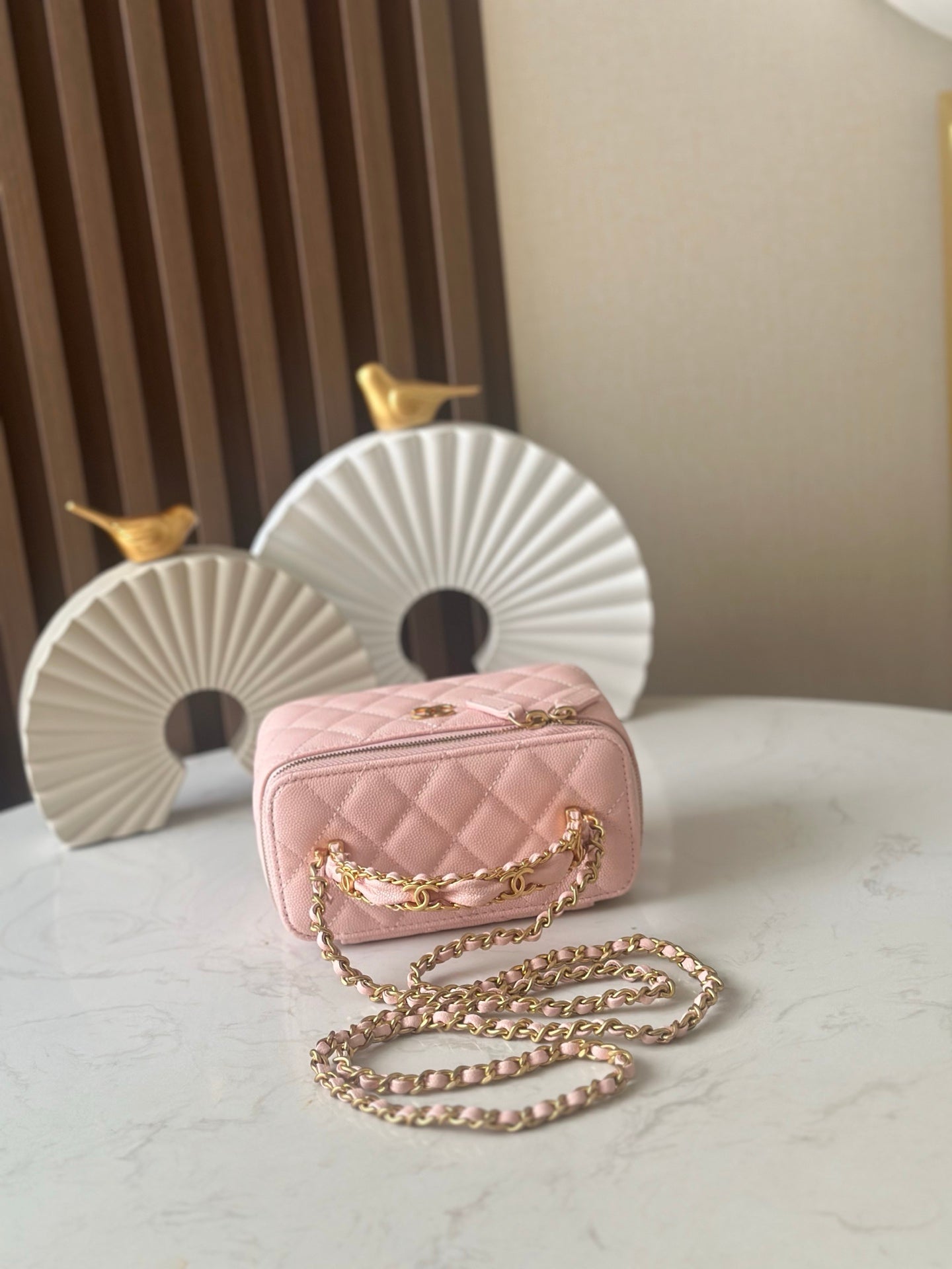 Chanel mini quilted bag in light pink with quilted front and gold chain shoulder strap
